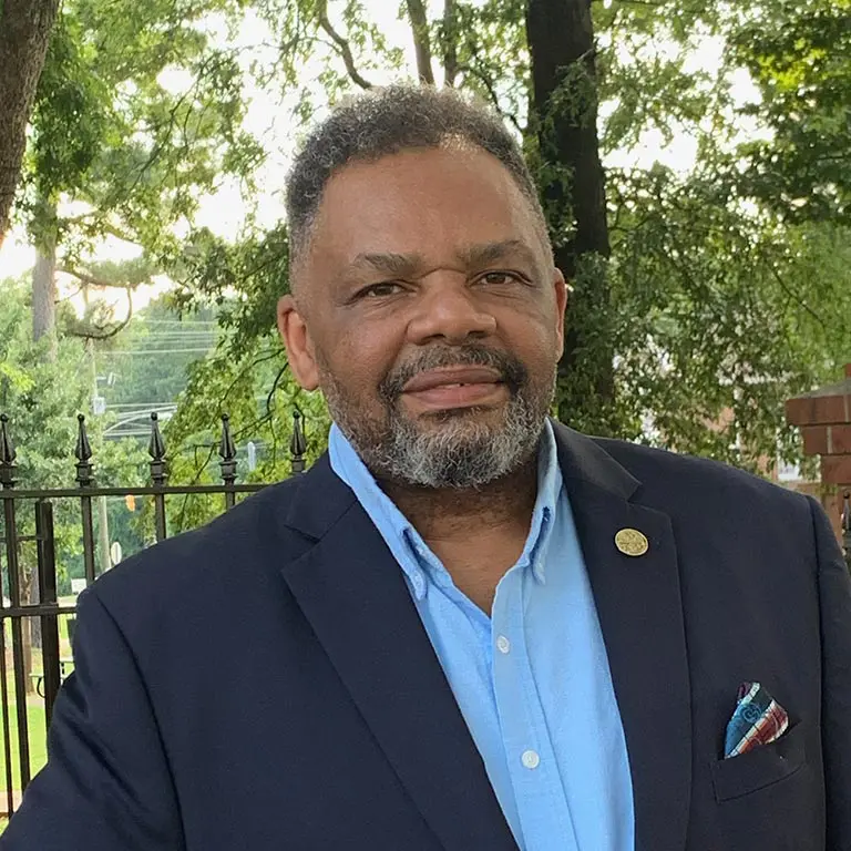 Smiling man in blazer outdoors